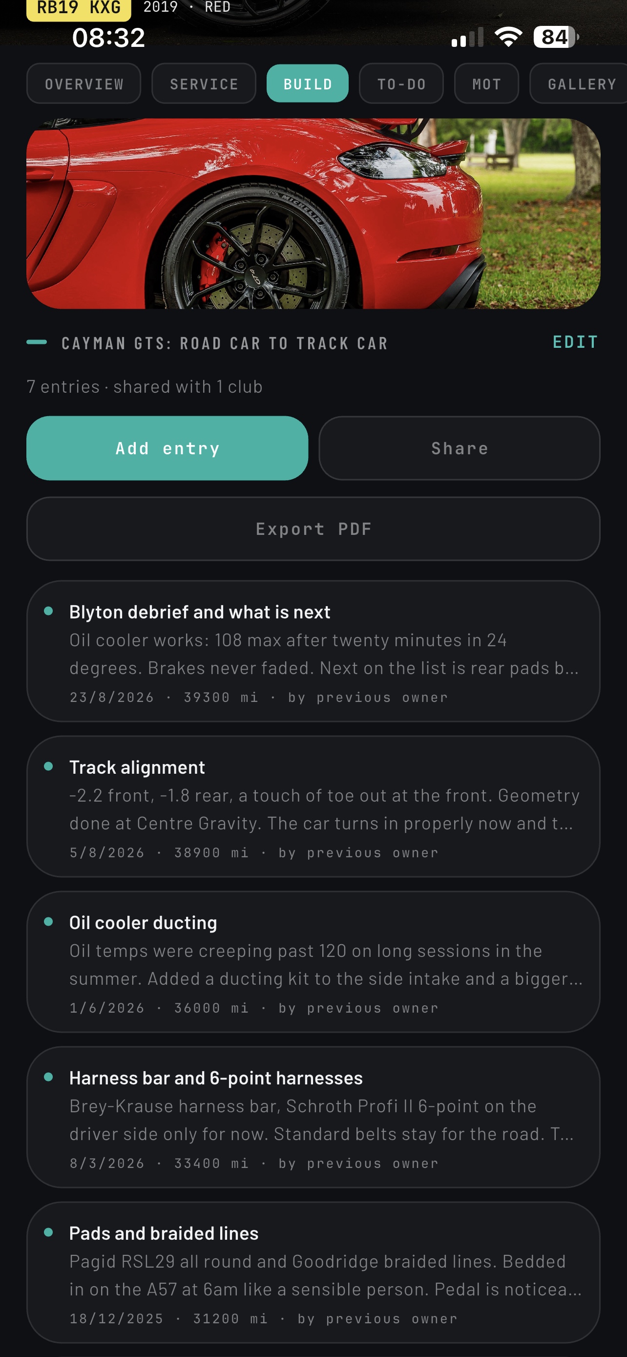 Build log in the RevBase app with dated entries for a Cayman track build: oil cooler ducting, harness bar and harnesses, pads and braided lines
